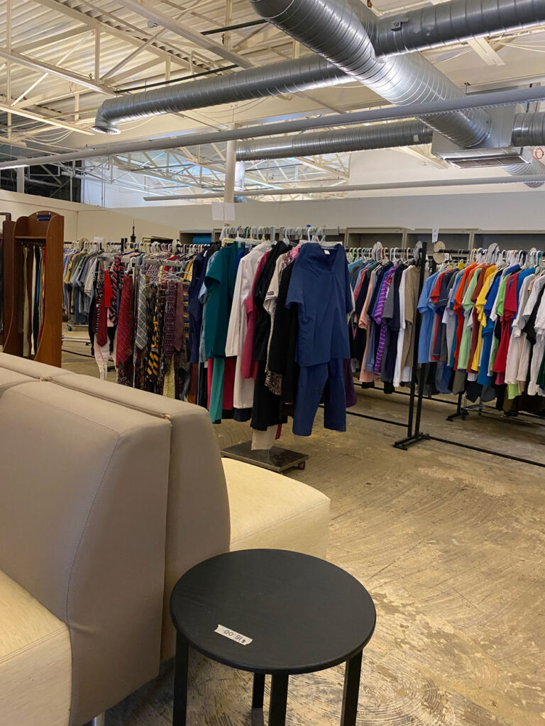 racks of clothes and furniture at our non-profit store